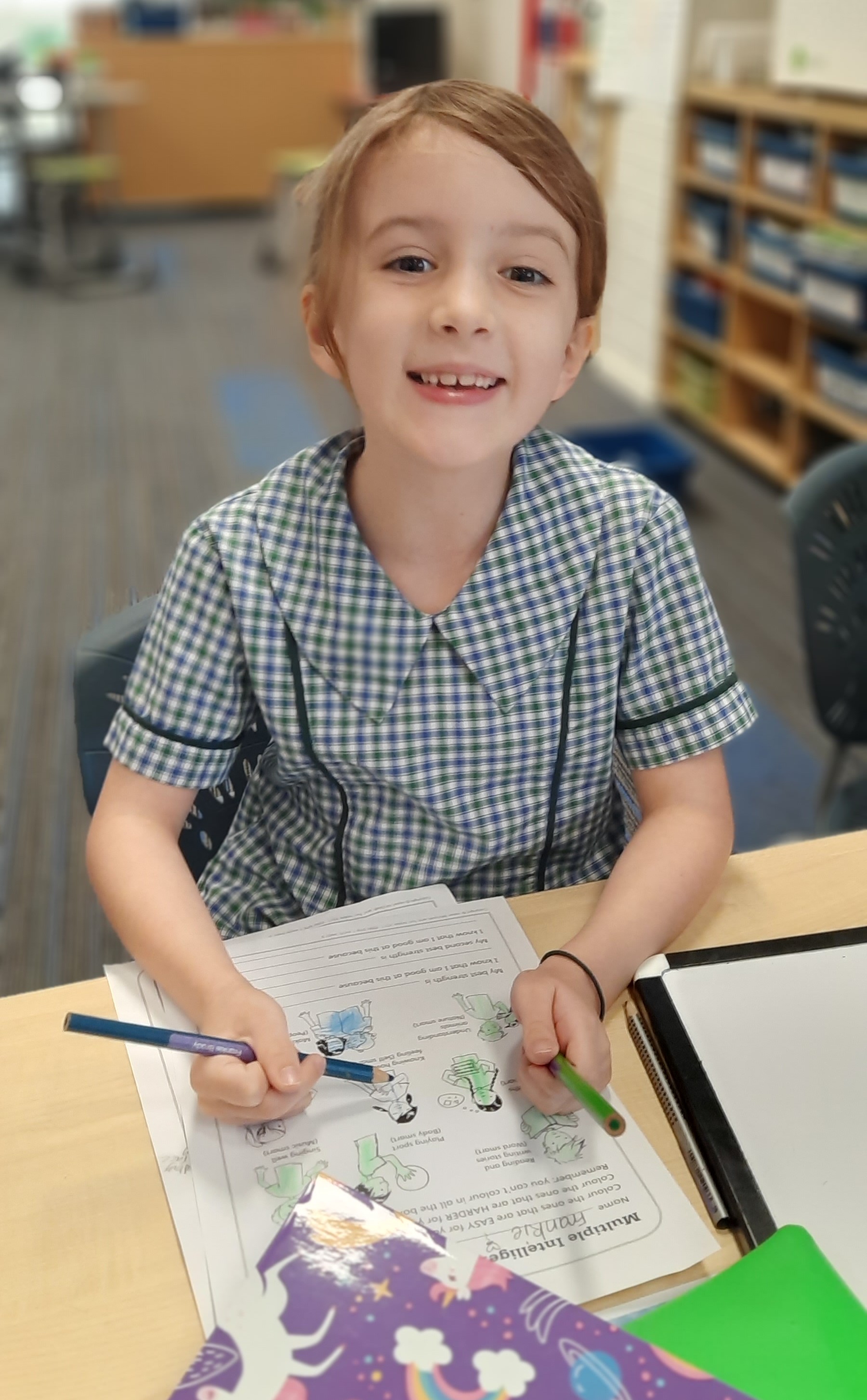 Student working on a writing activity at a classroom desk, highlighting focus independence and early years learning at St Pius X Primary School