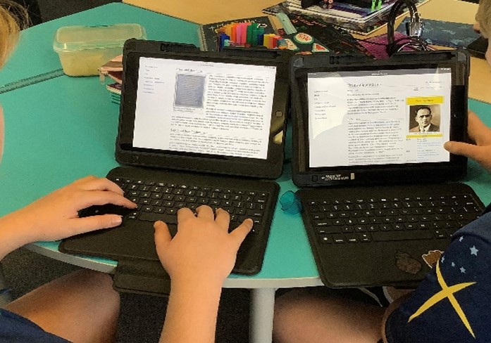 Student working with digital devices in pairs, highlighting collaborative learning research skills and technology enhanced learning at St Pius X Primary School
